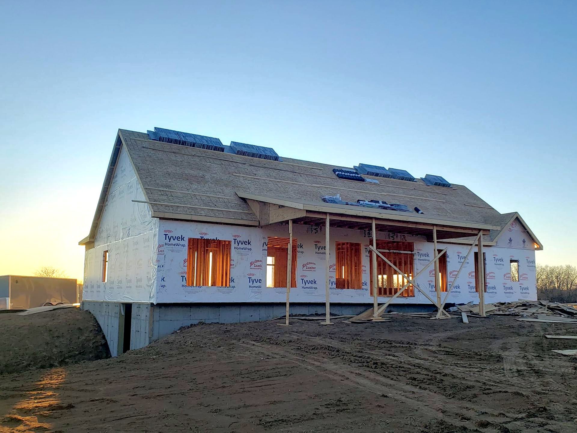 A house is being built in the middle of a dirt field.