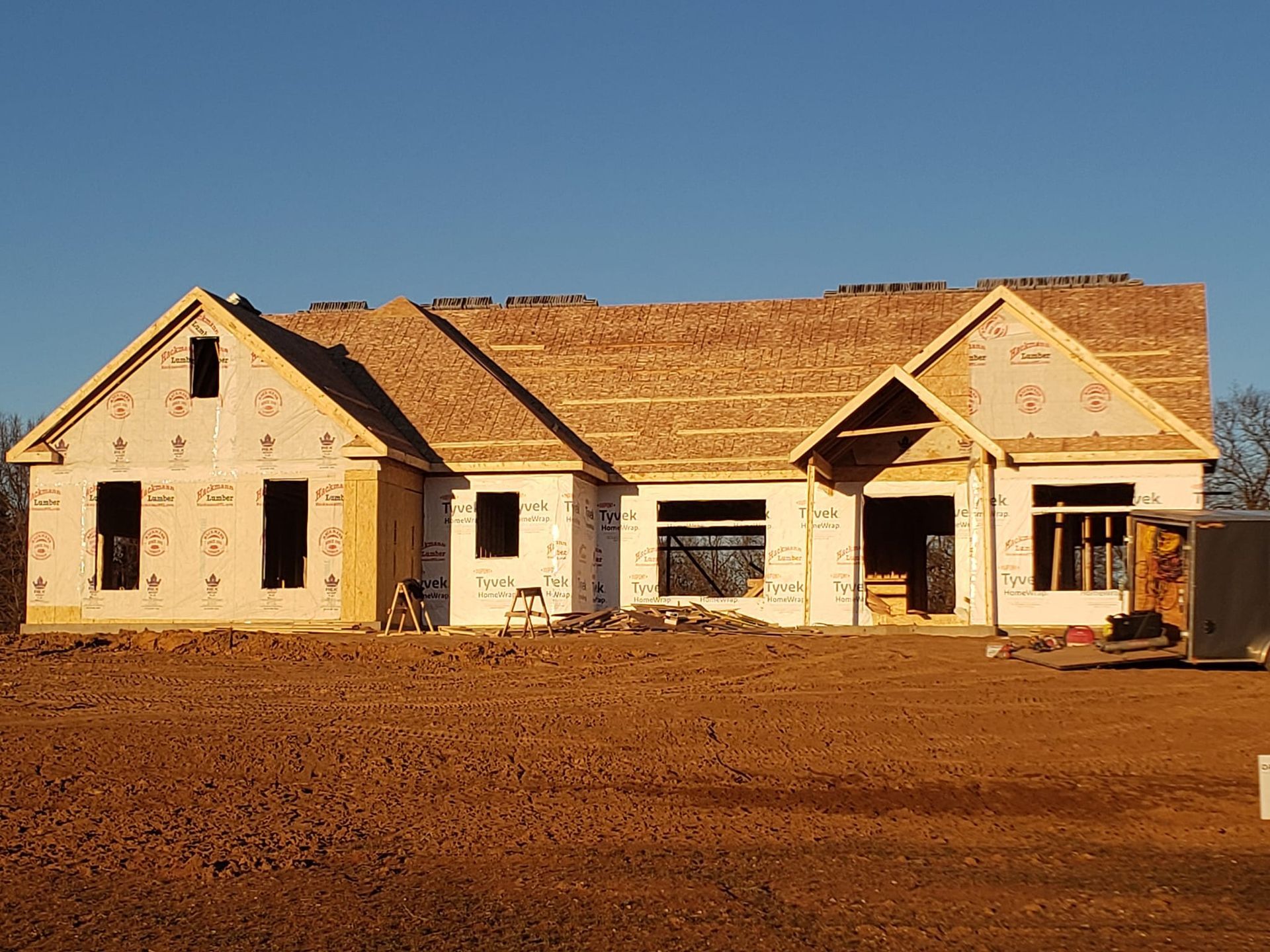 A house is being built in a dirt field.