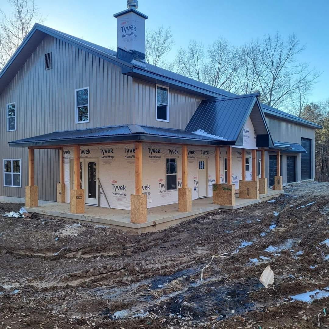A house under construction with a porch and a chimney