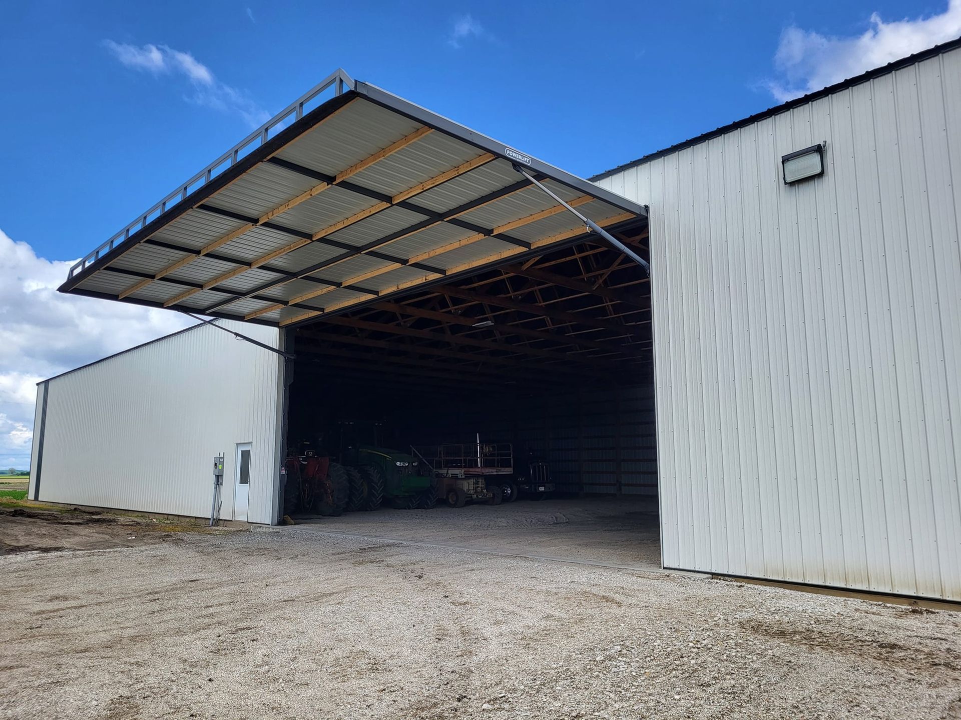 A large white building with a roof that is open.