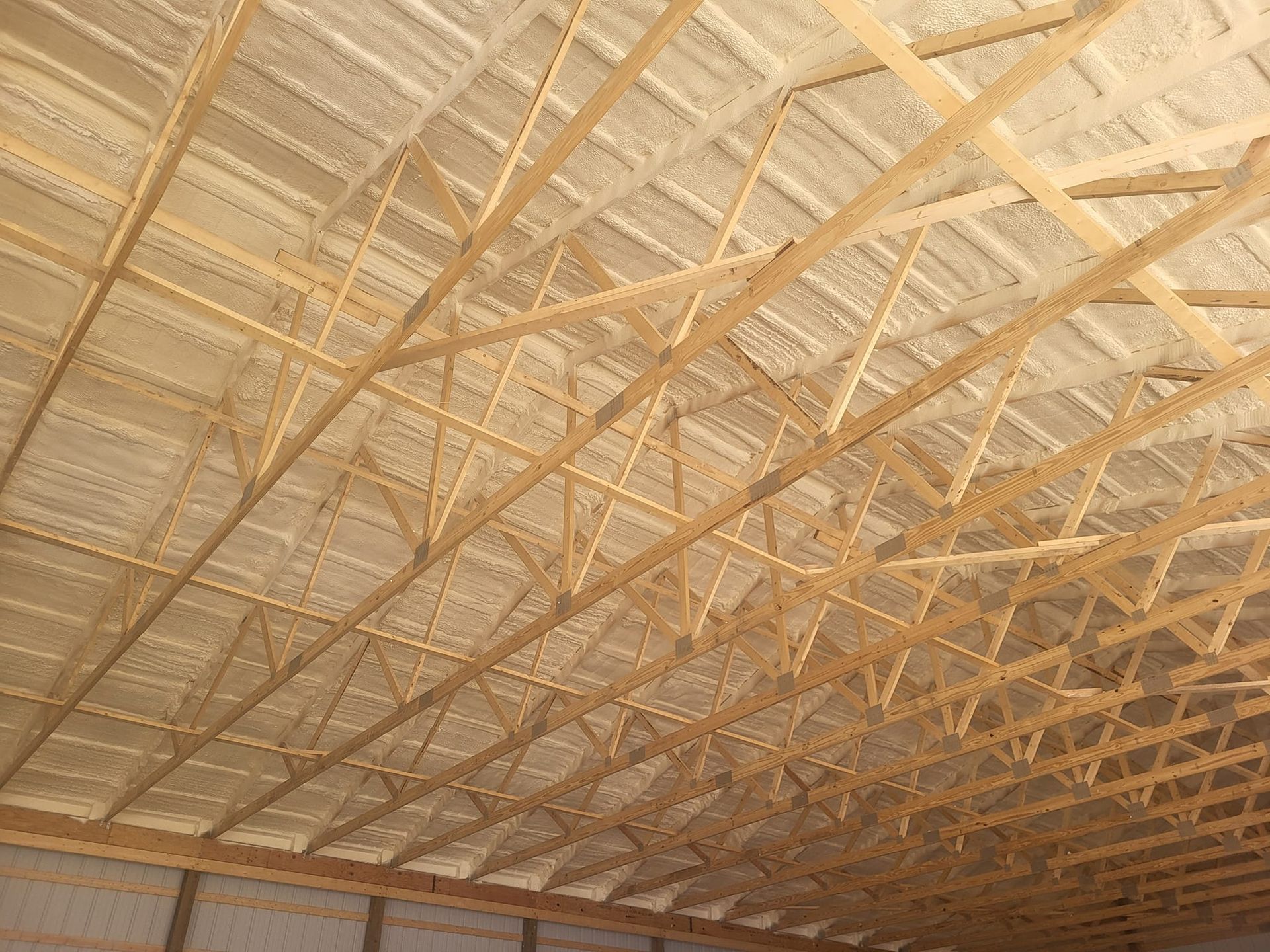 The ceiling of a building under construction with a lot of wooden beams.