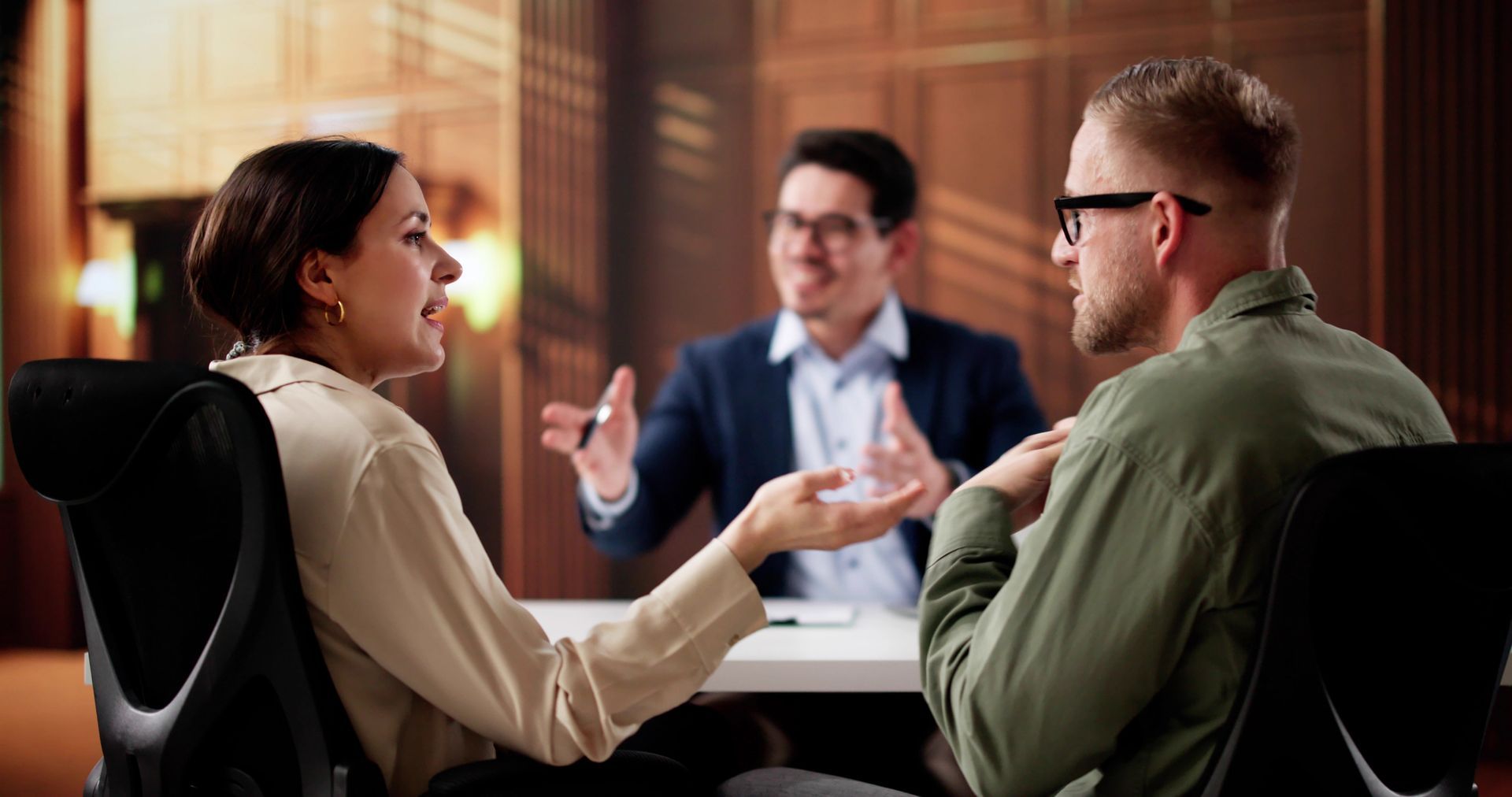 a man and woman sitting at a desk with their mediation attorney