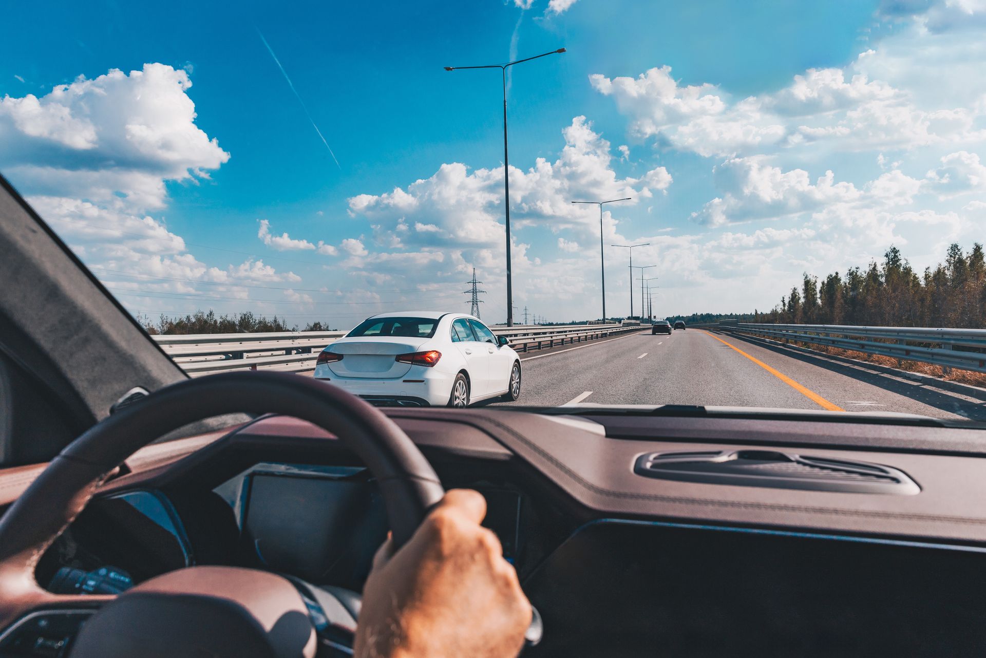 Man driving modern car from rear view on the highway.