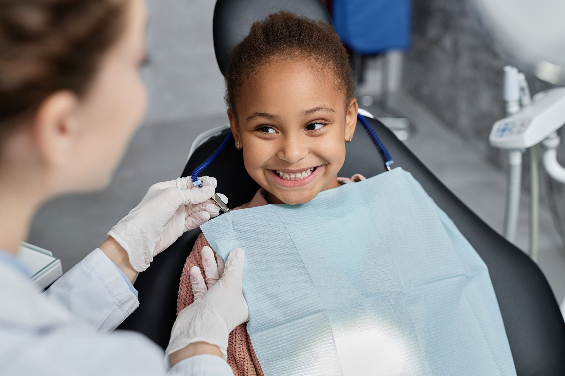 A dentist is prepping a child for a dental checkup.