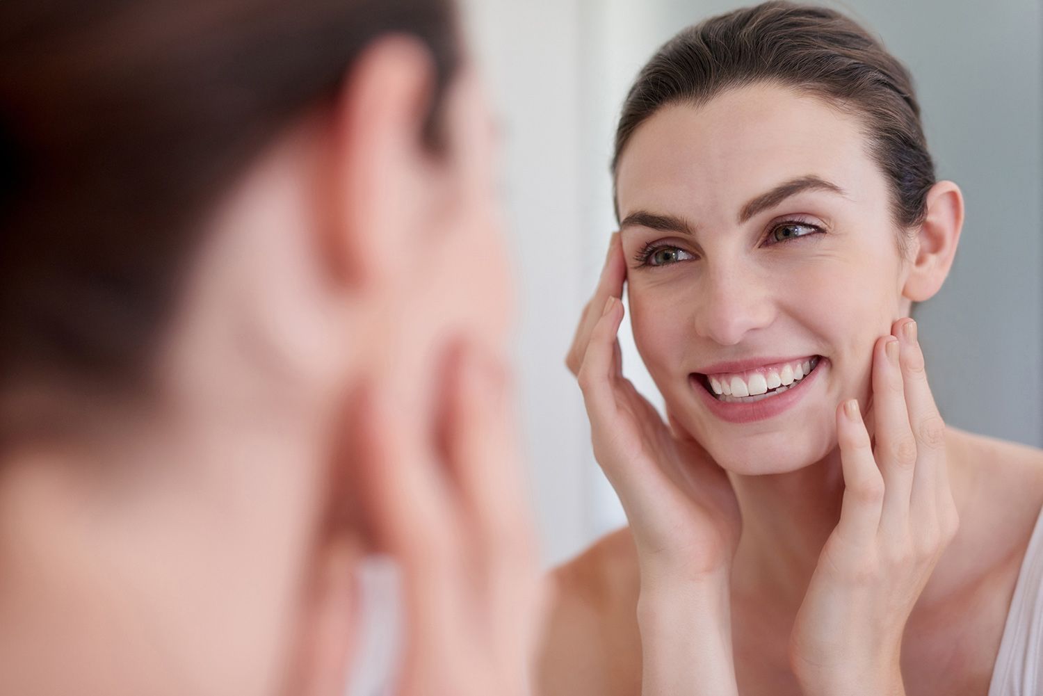 Woman Looking at her Face in the Mirror — Tucson, AZ — Associated Dermatologist