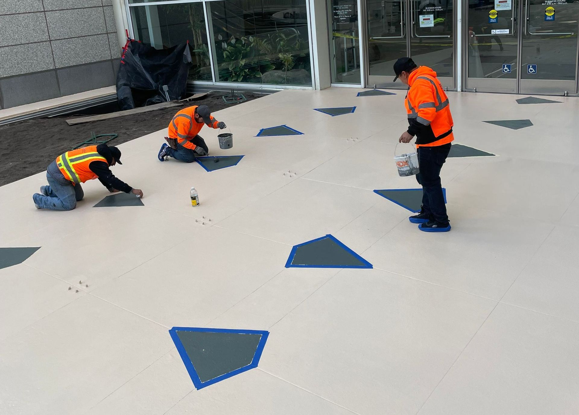 Three men are working on a tiled floor in front of a building.  | Oakland, CA  | Diablo Roofing