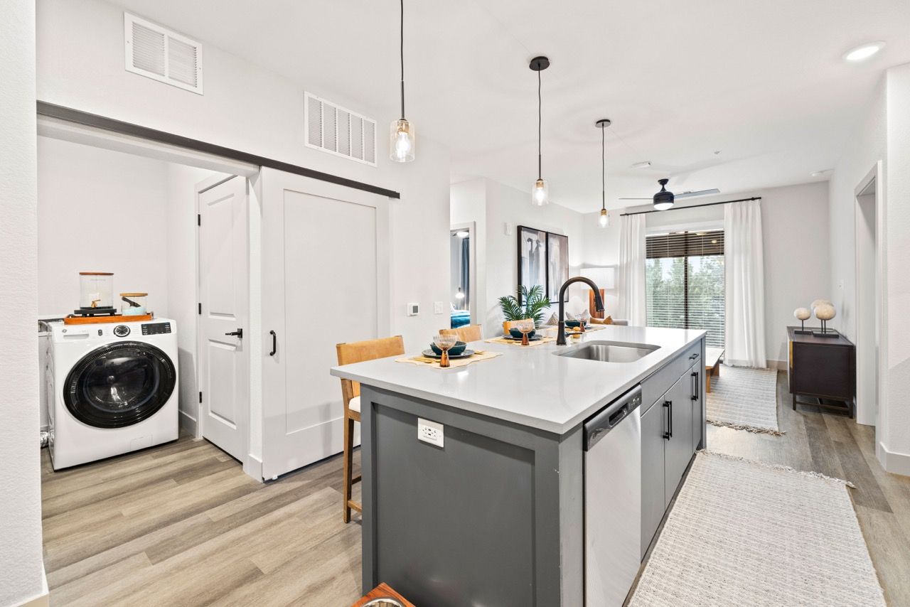 Open-concept kitchen with island, sink, and a visible laundry closet.
