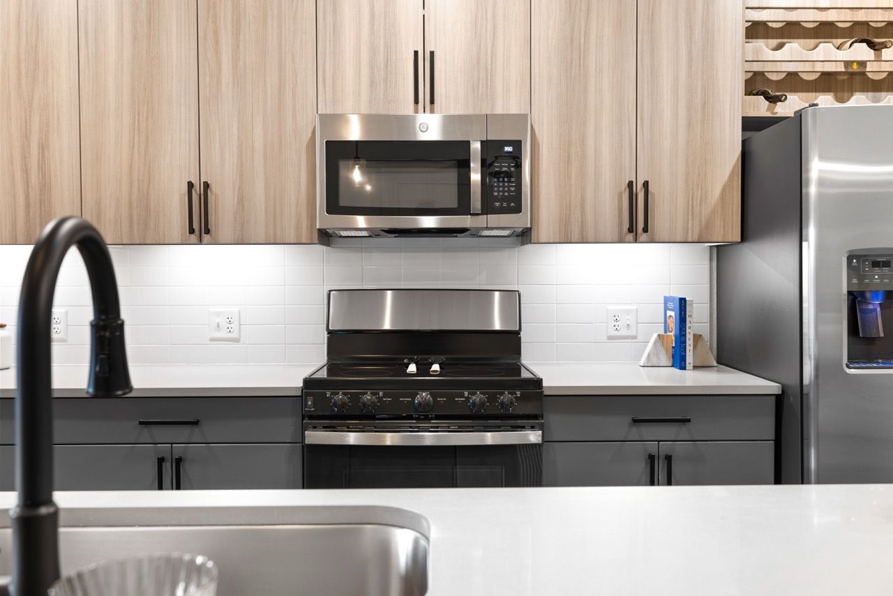 Modern kitchen with stainless steel appliances and light wood cabinets.