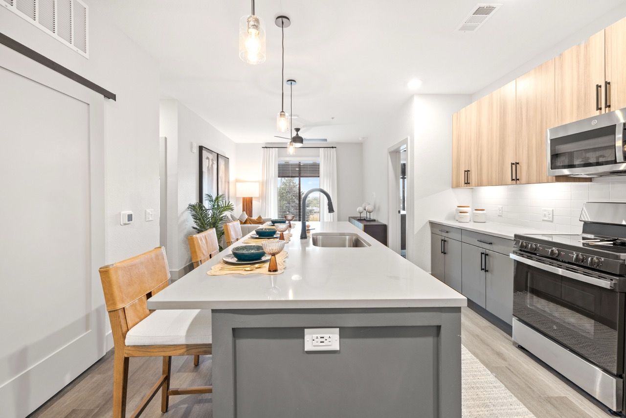 Bright contemporary kitchen with a large island, seating, and stainless-steel appliances.