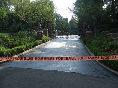 A gated driveway with a sign that says budget sealers