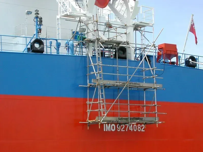 Scaffolding on the side of a large ship with imo 92740682 written on it