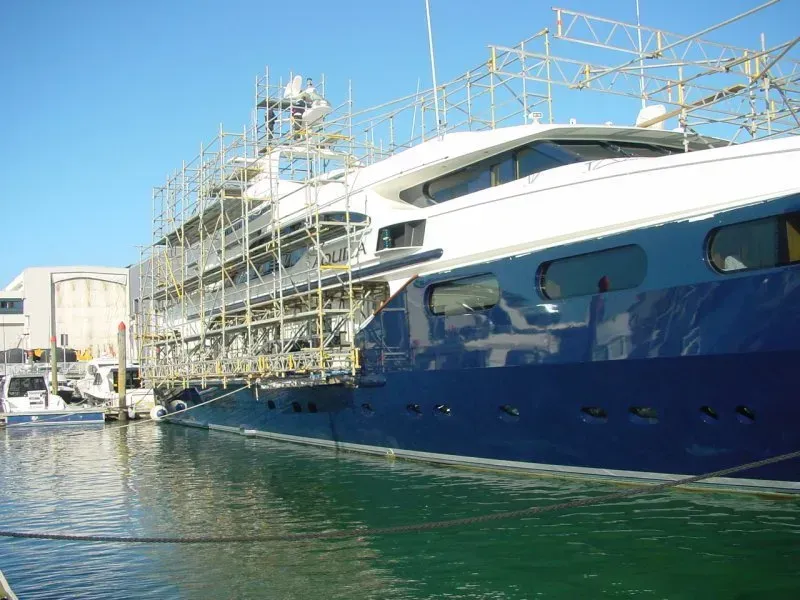 A large blue and white yacht is docked in a harbor.