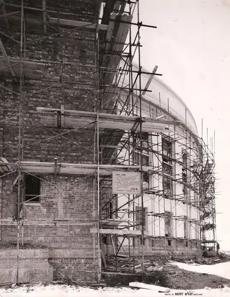 A black and white photo of a building under construction