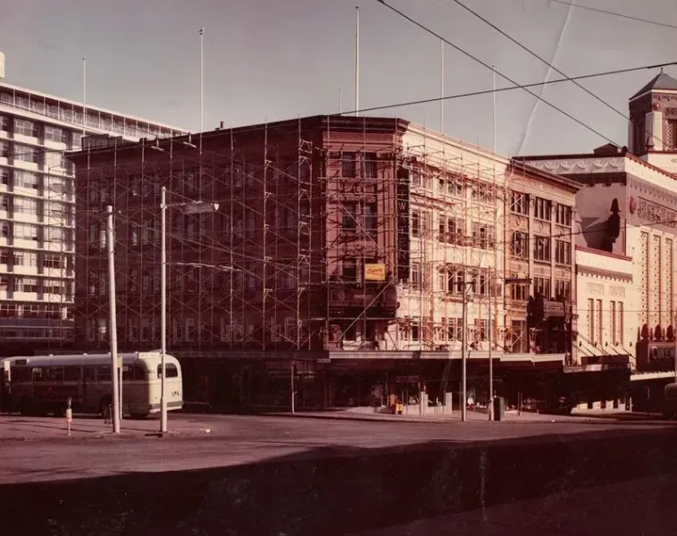 A bus is parked in front of a building under construction