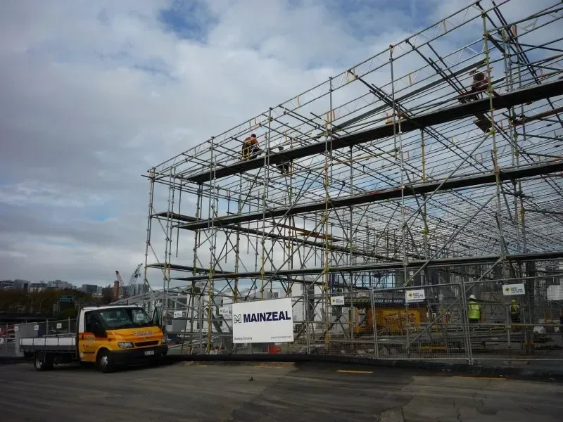A truck is parked in front of a building under construction.