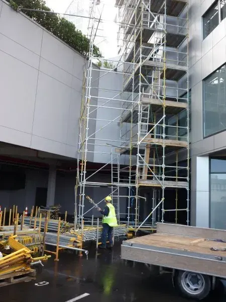 A truck is parked in front of a building with scaffolding on it