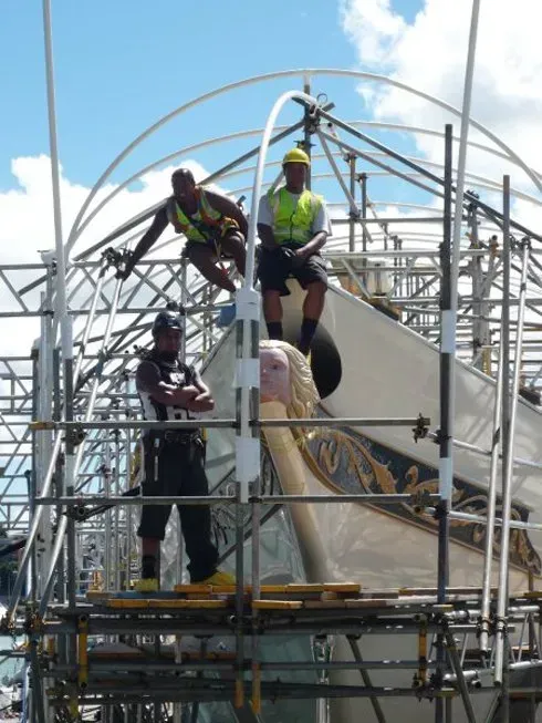 A group of construction workers standing on top of a scaffolding structure