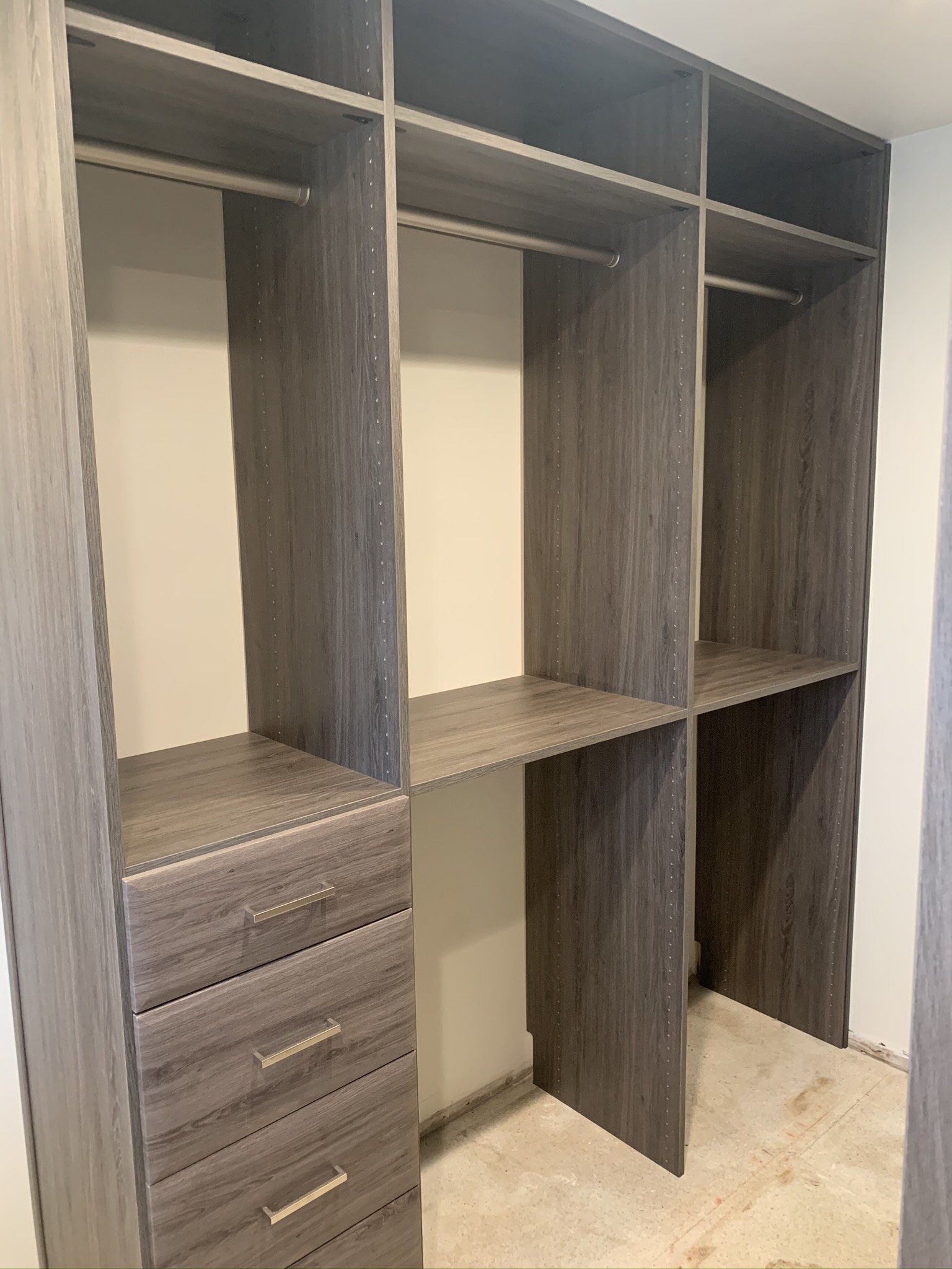 A walk in closet with lots of shelves and drawers.