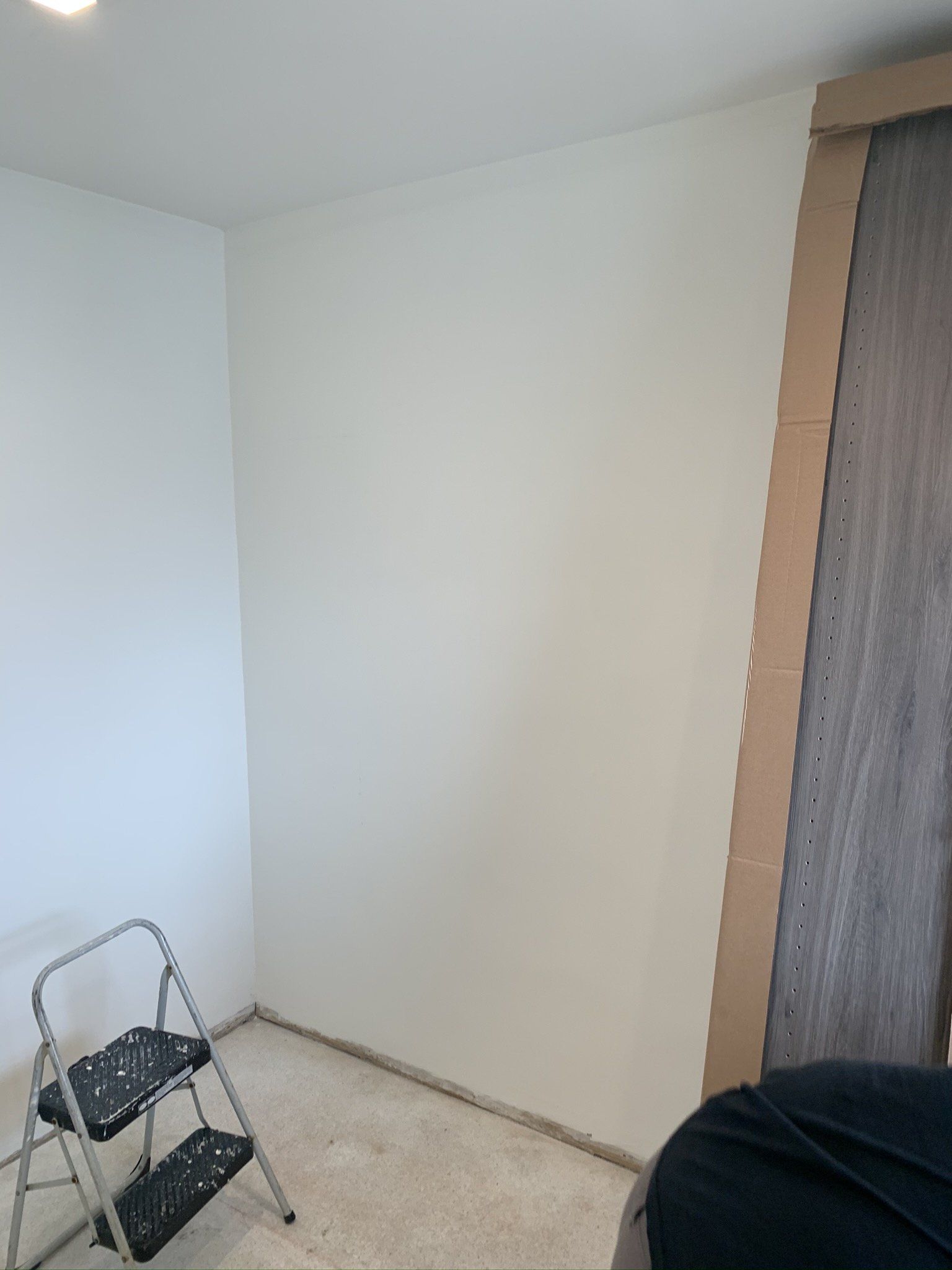 A ladder is sitting in a room next to a wall.