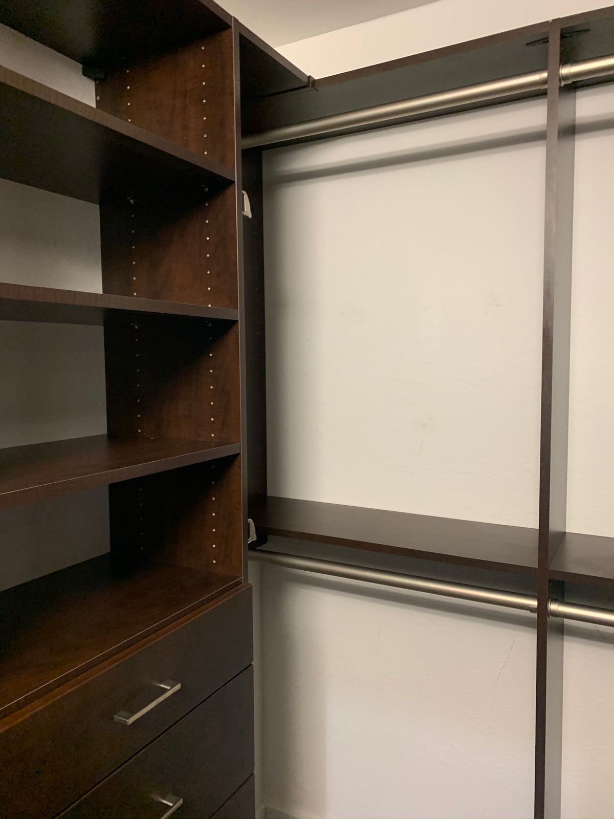 A walk in closet with lots of shelves and drawers.
