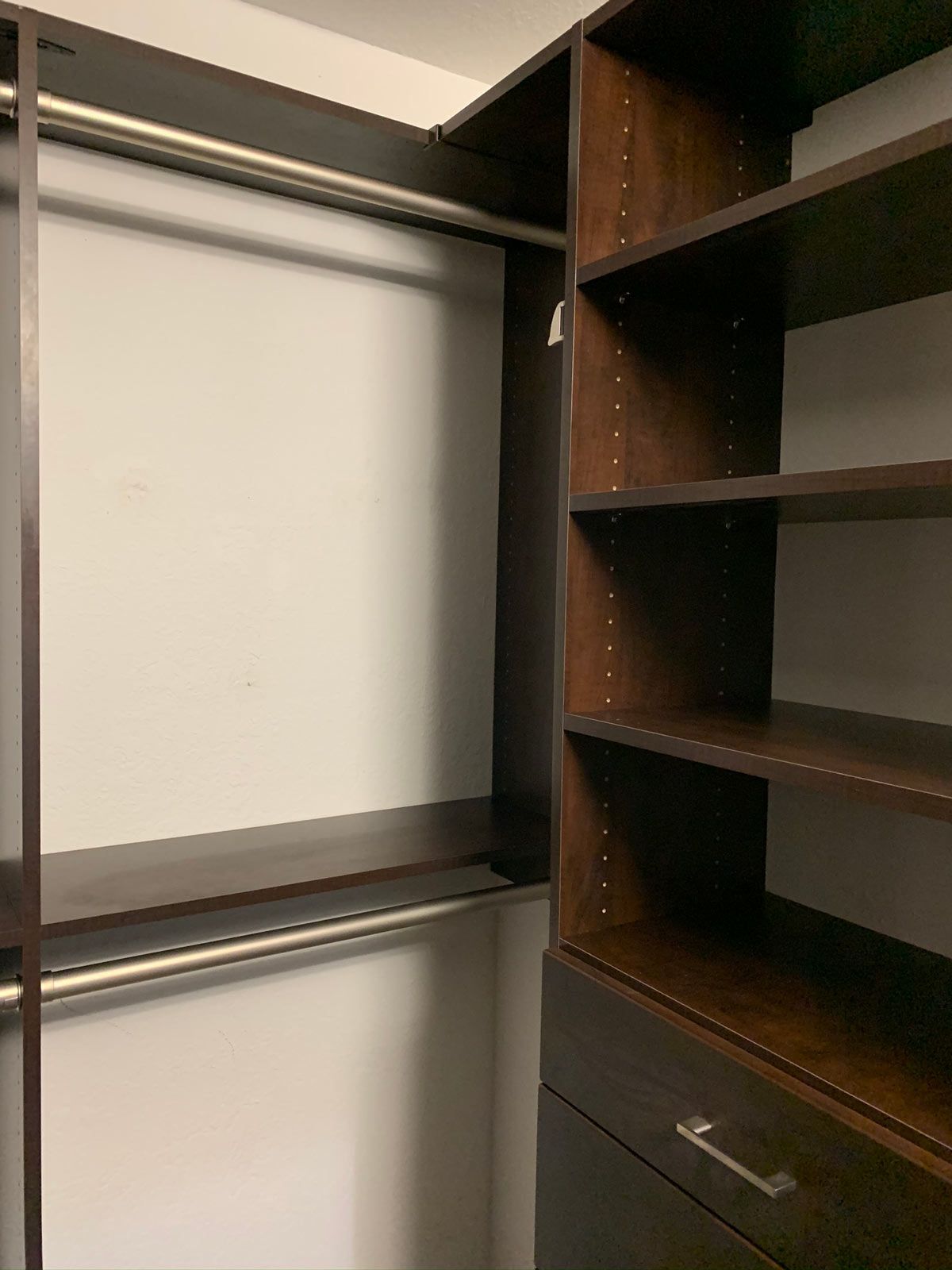 A walk in closet with lots of shelves and drawers.