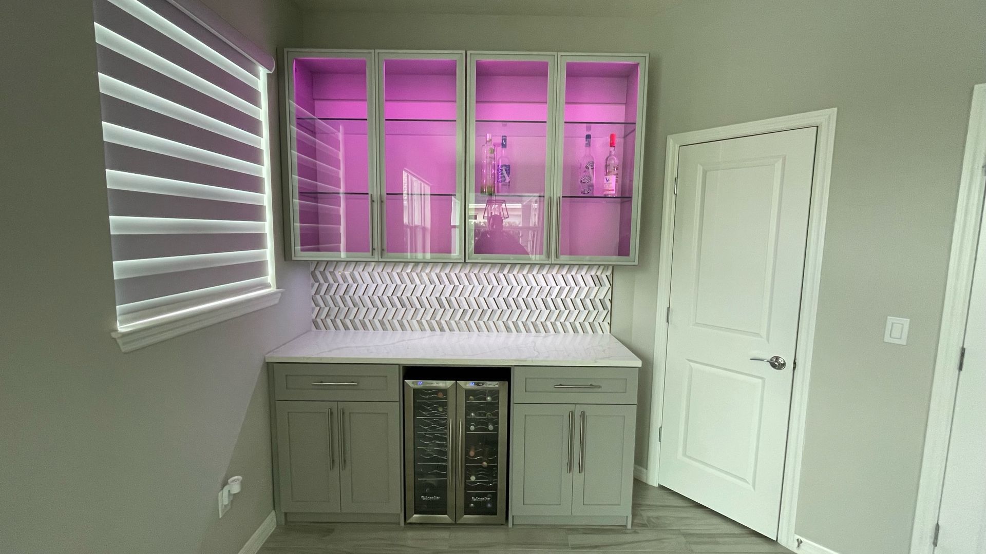 A kitchen with a bar and a wine cooler.