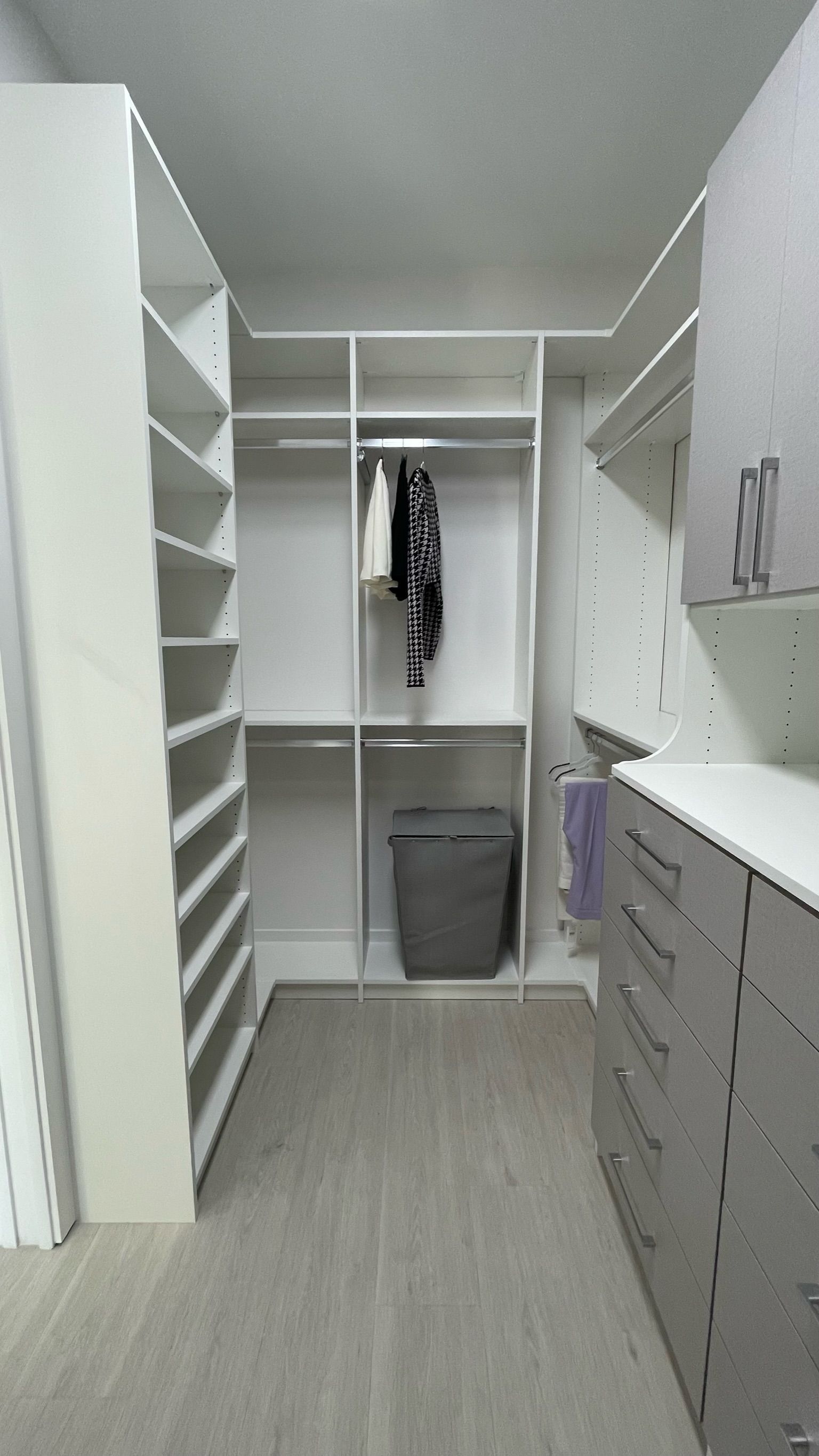 A walk in closet with lots of shelves and drawers.