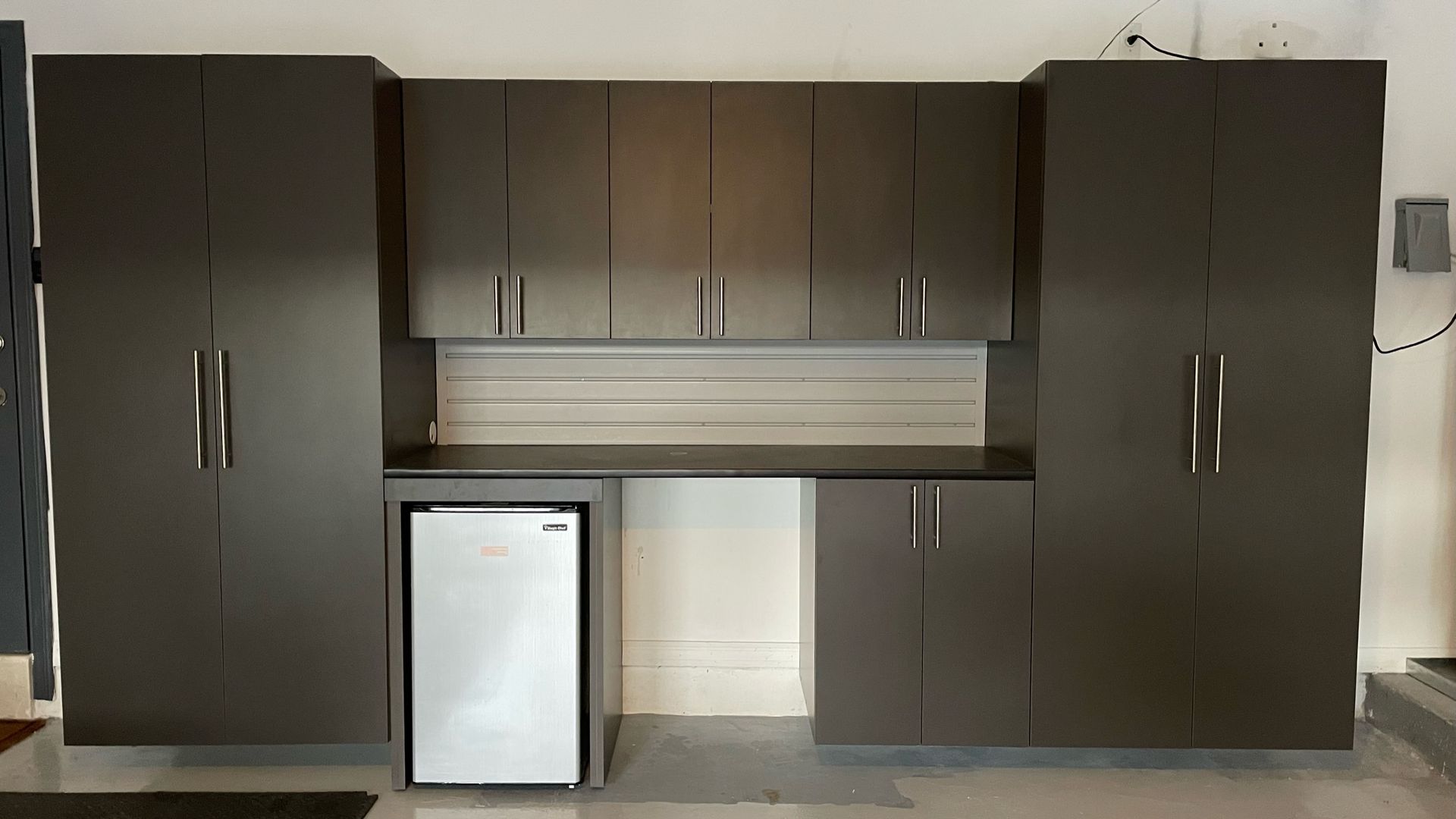 A kitchen with lots of cabinets and a small refrigerator