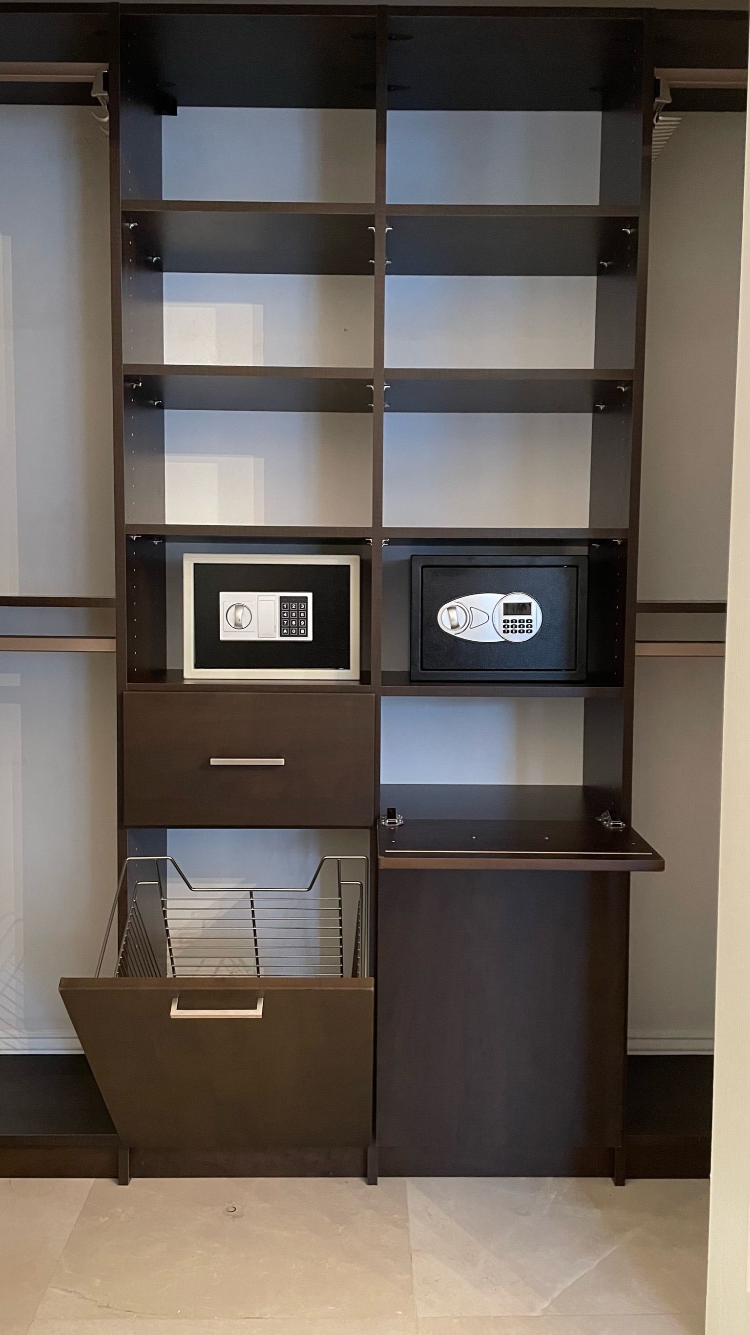 A closet with shelves drawers and a safe