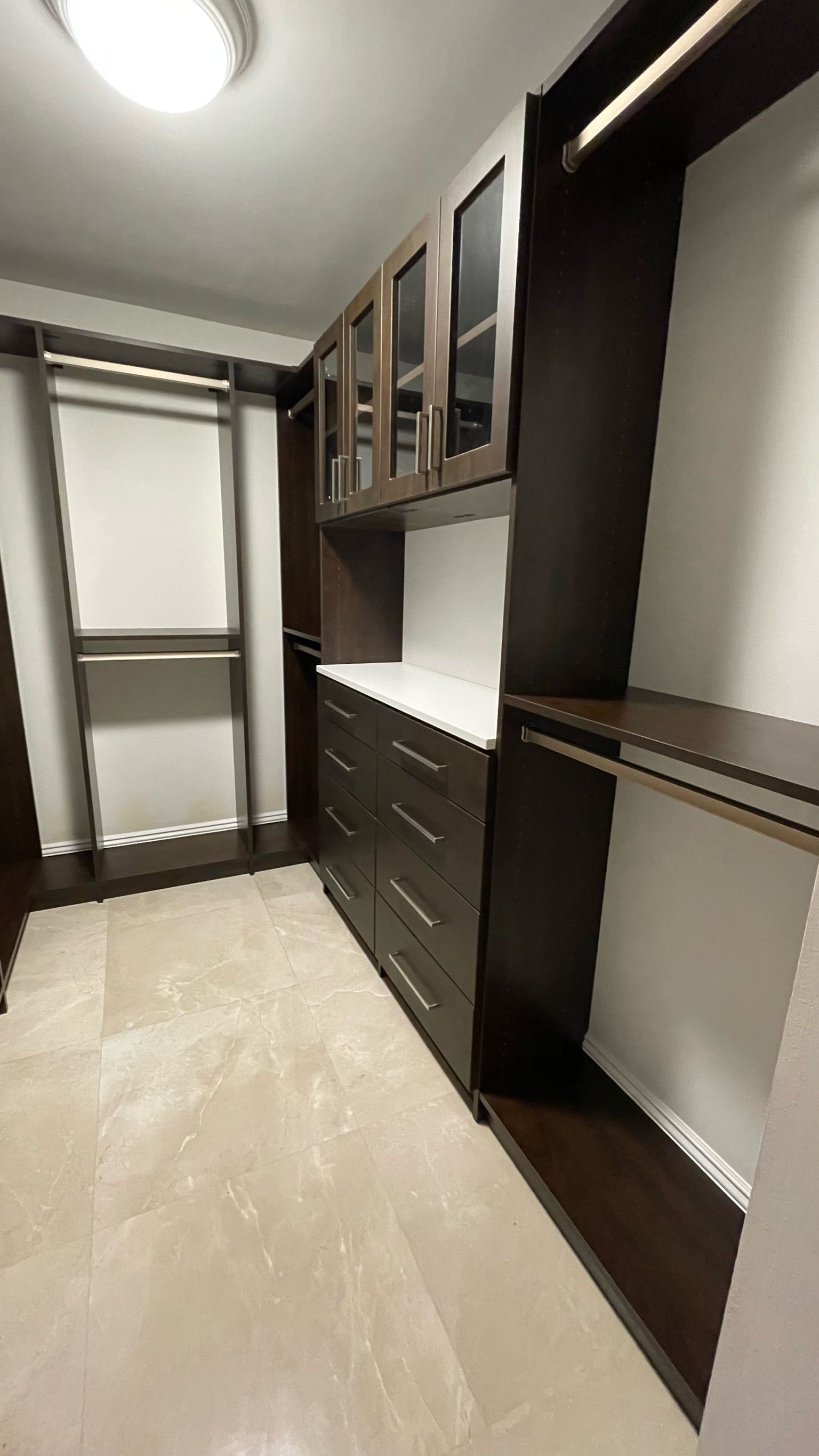 A walk in closet with lots of shelves and drawers.