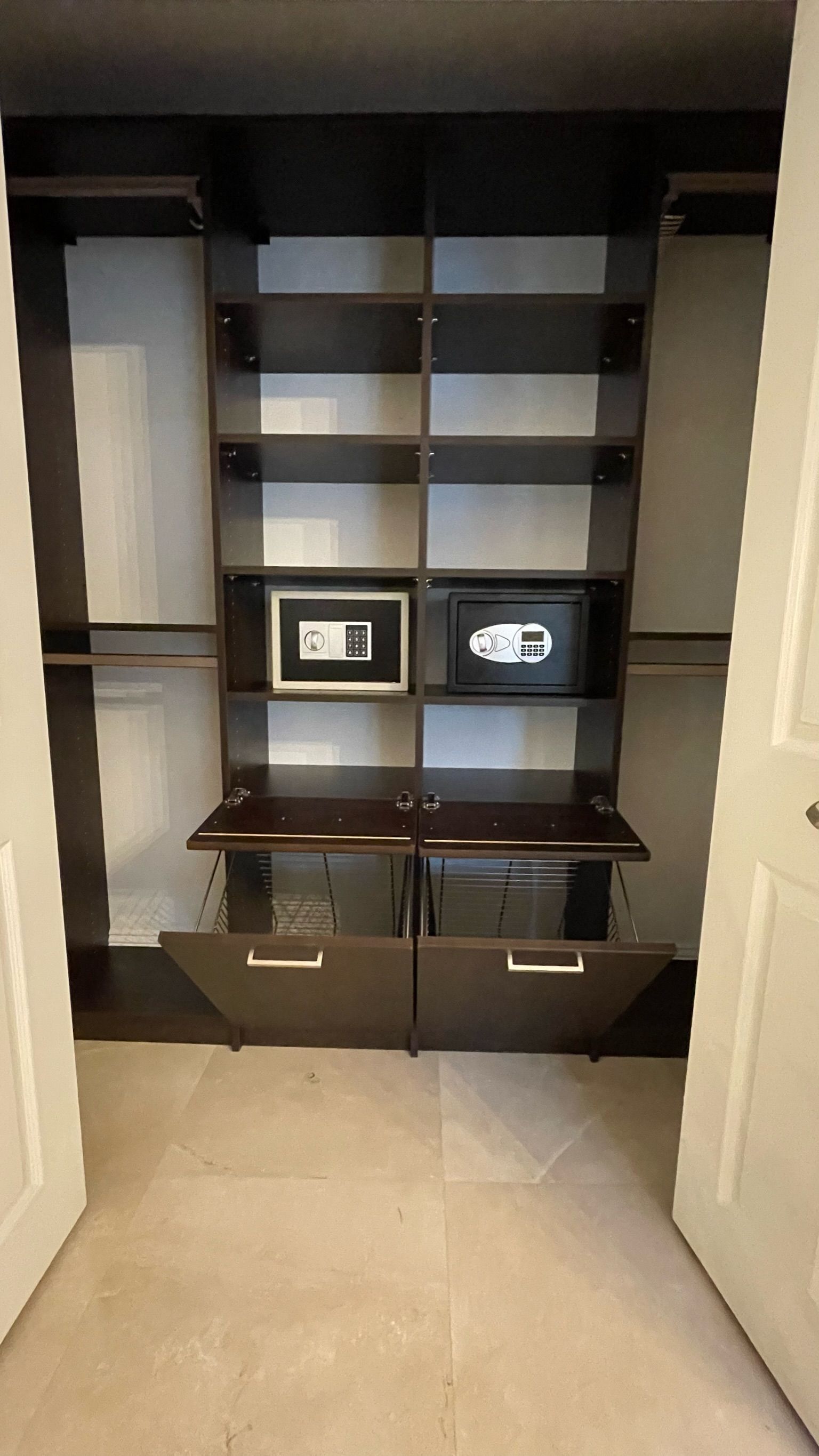 A walk in closet with shelves and drawers and a safe.