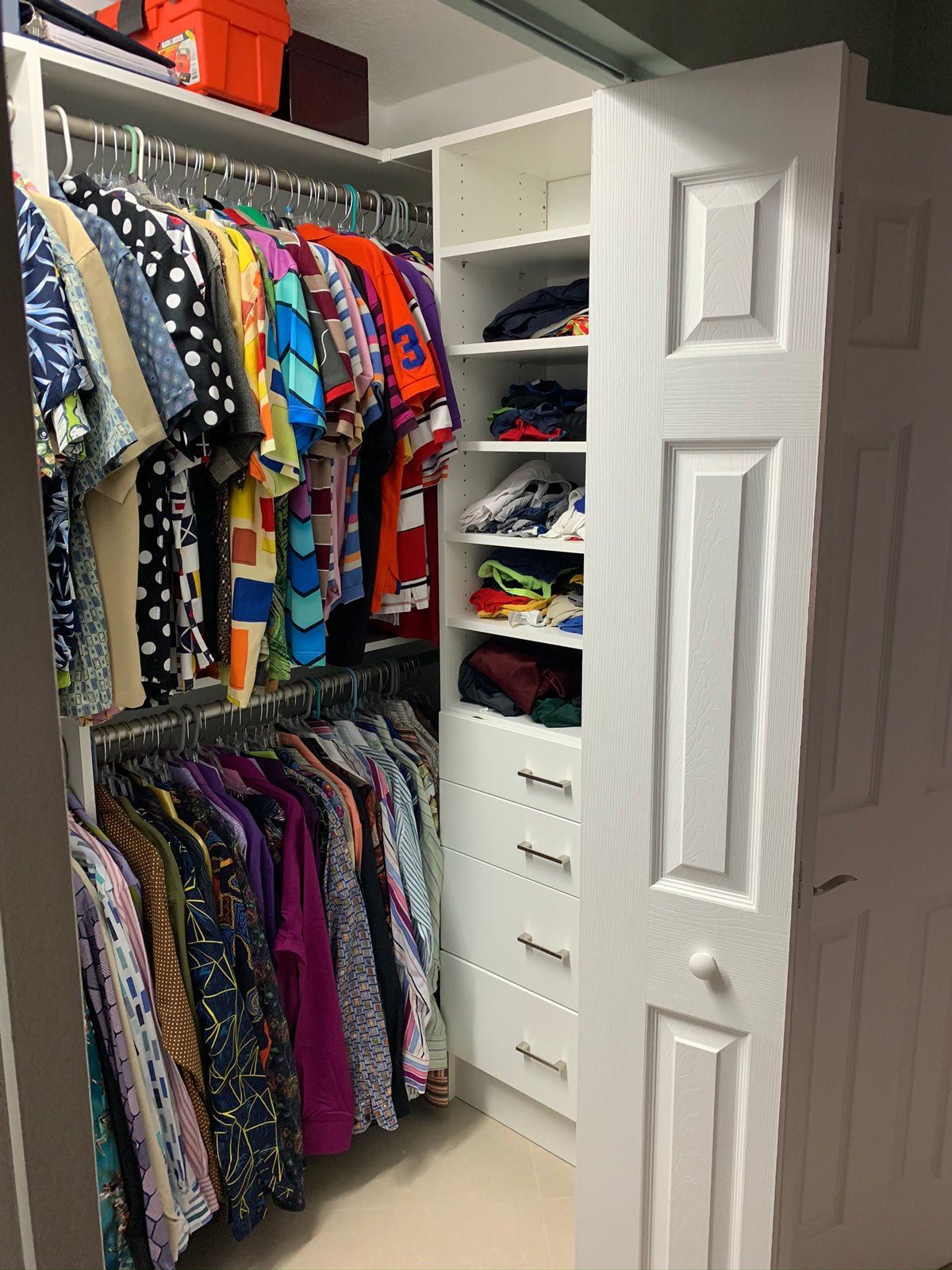 A closet filled with lots of clothes and a white door.