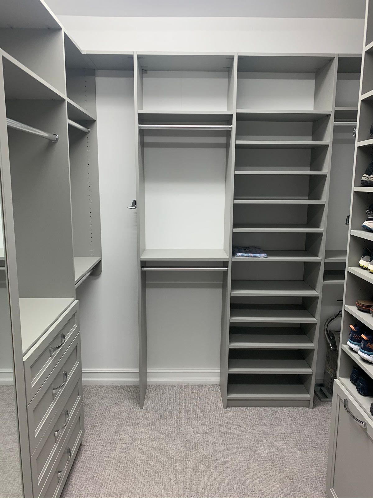 A walk in closet with lots of shelves and drawers.