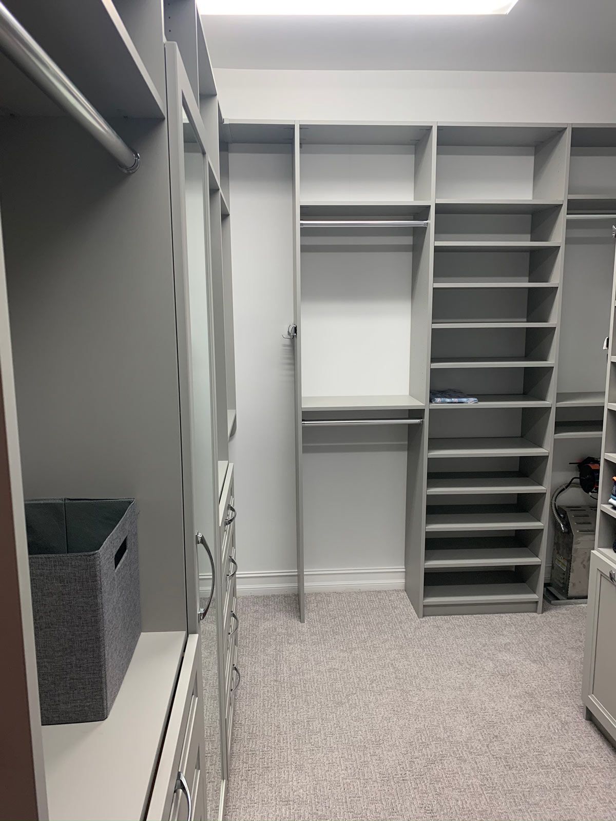 A walk in closet with lots of shelves and drawers.