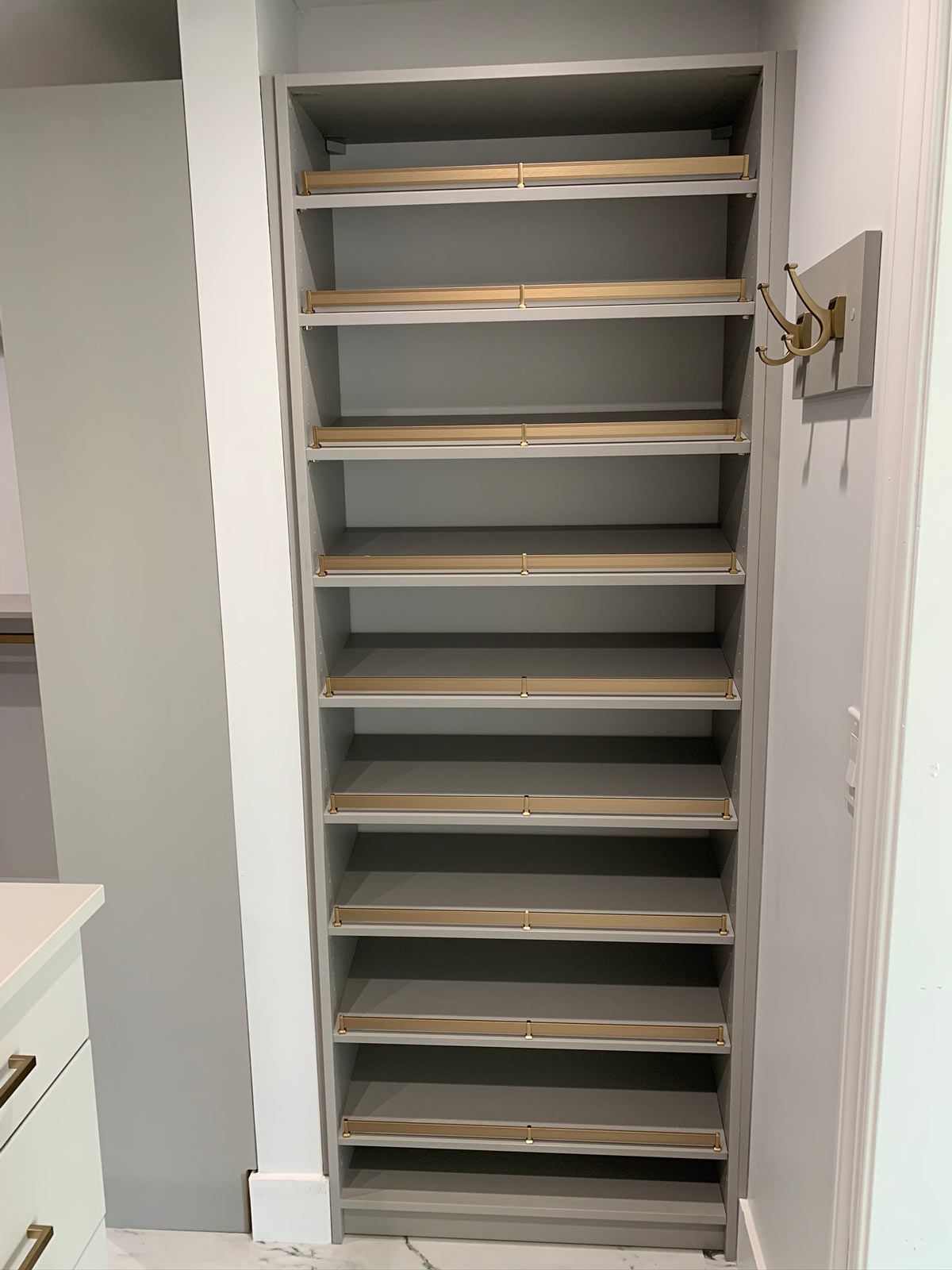 A closet with a lot of shelves and a hook on the wall.