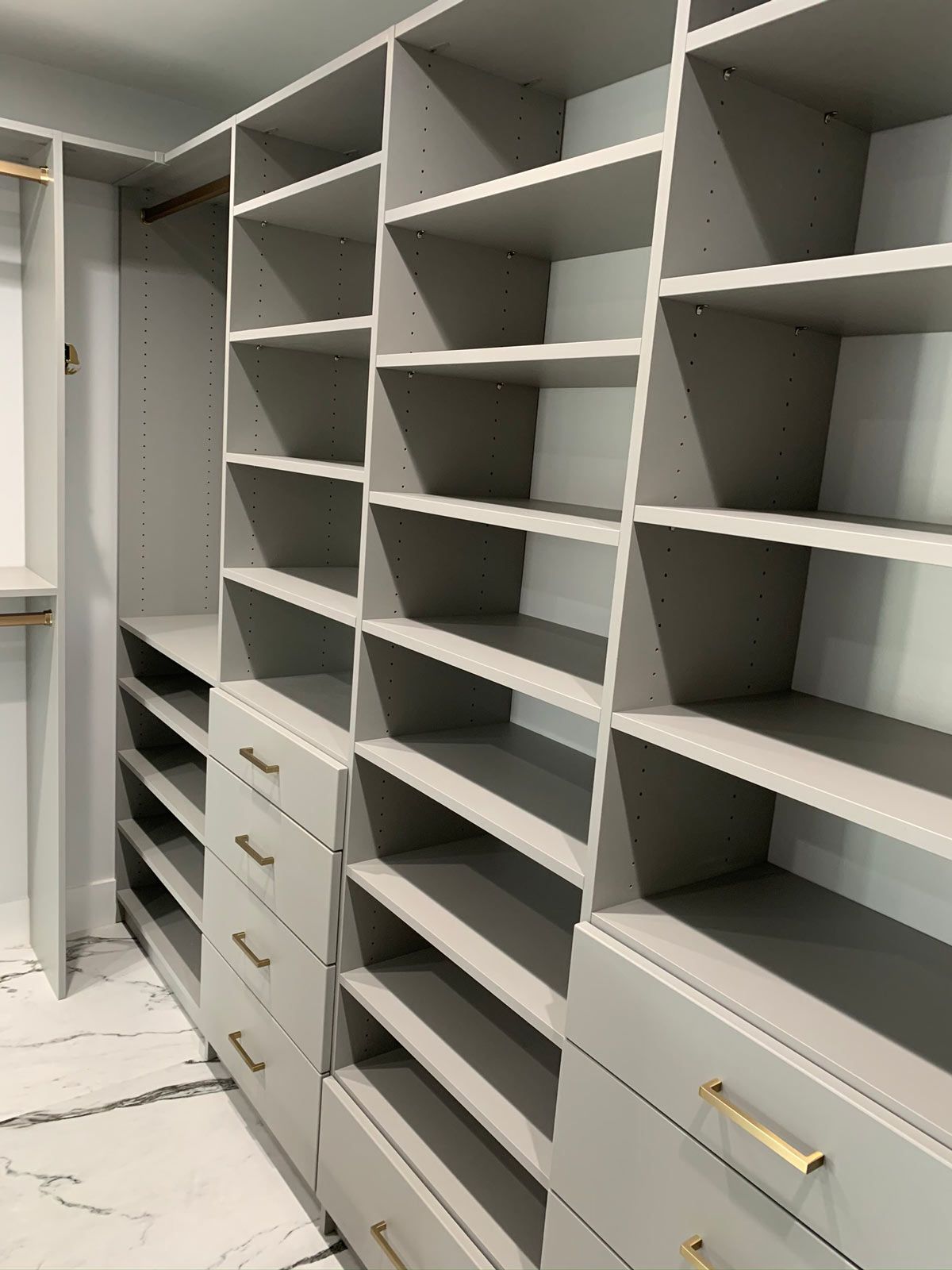 A walk in closet with lots of shelves and drawers.