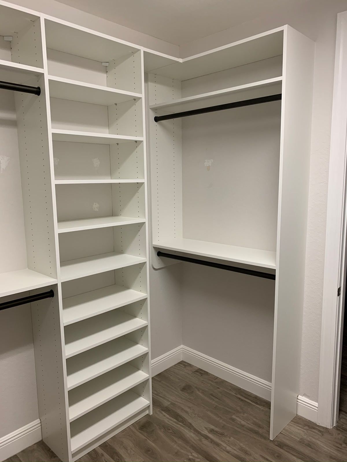 A walk in closet with lots of shelves and hanging racks.