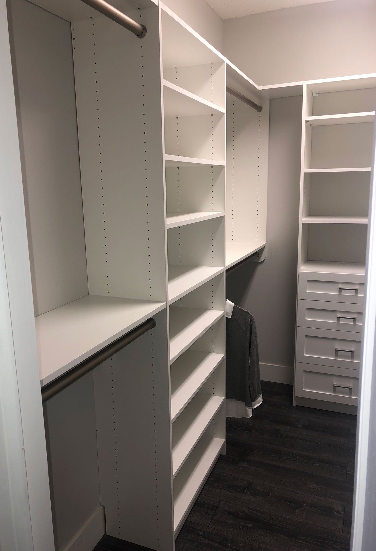 A walk in closet with lots of shelves and drawers.