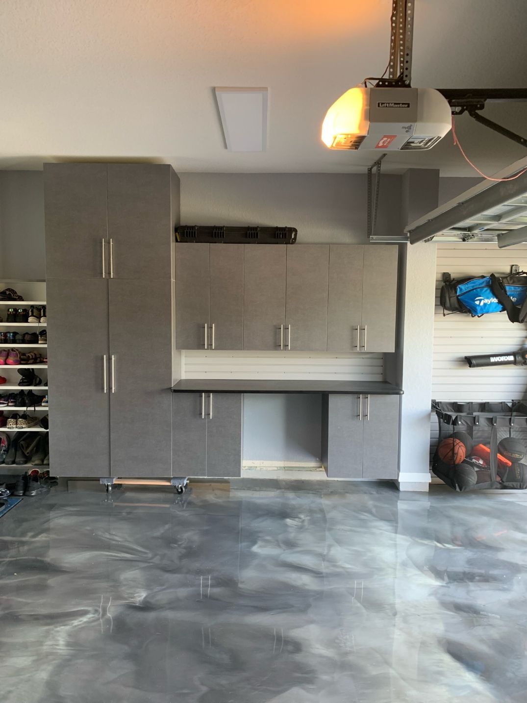 Pewter Garage Cabinets With Slatwall Organizer System and Epoxy Flooring