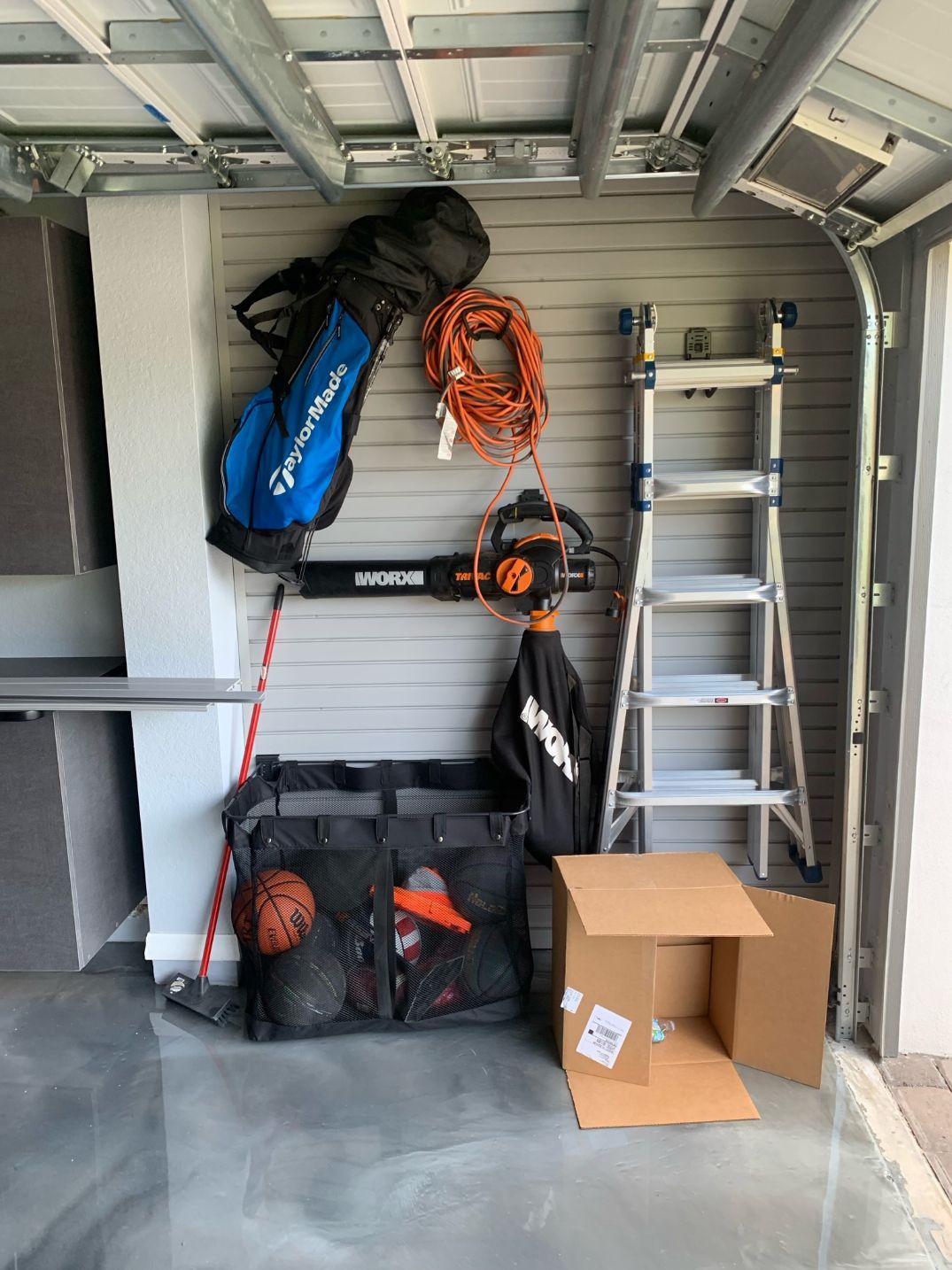 Pewter Garage Cabinets With Slatwall Organizer System and Epoxy Flooring