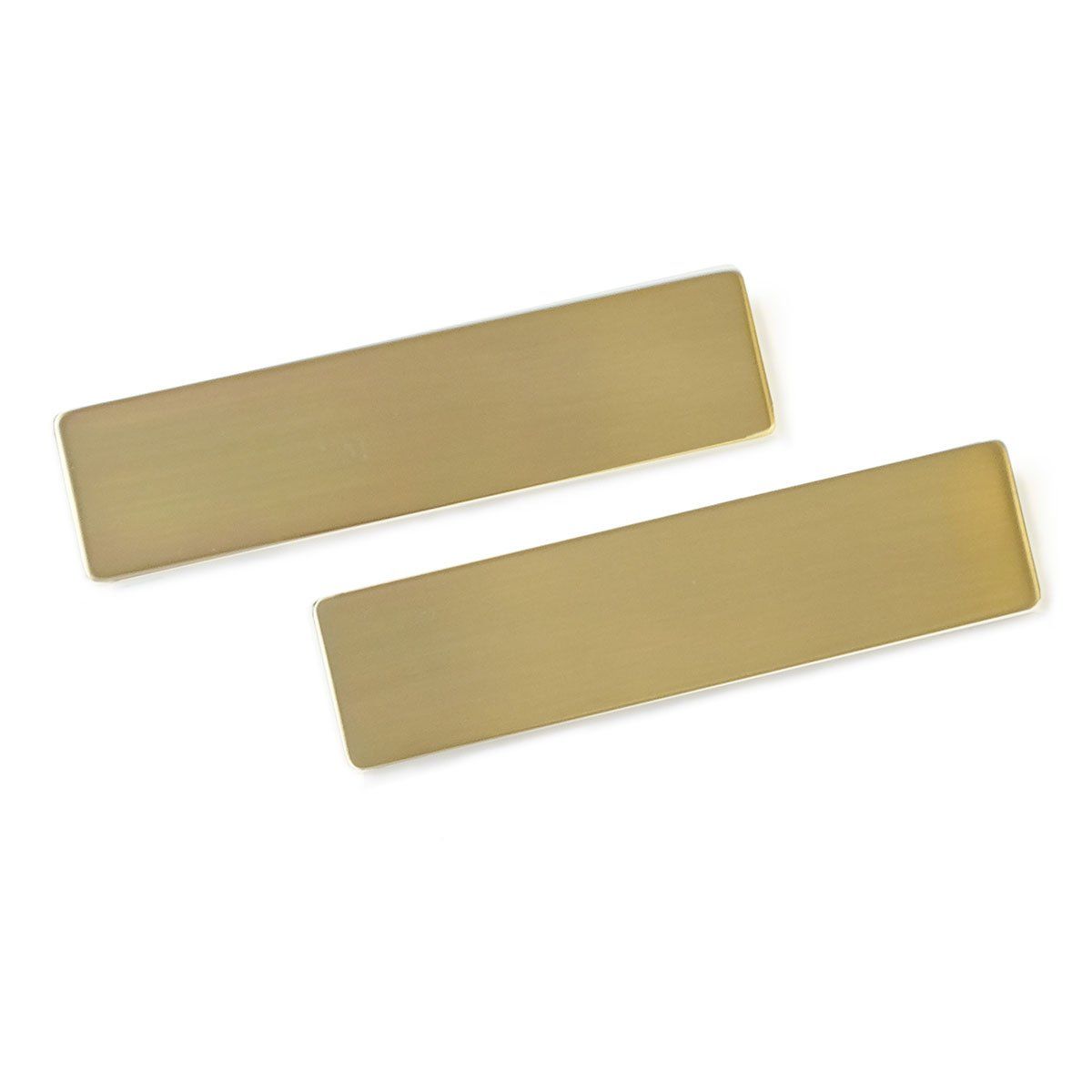 A pair of brass name tags on a white background.
