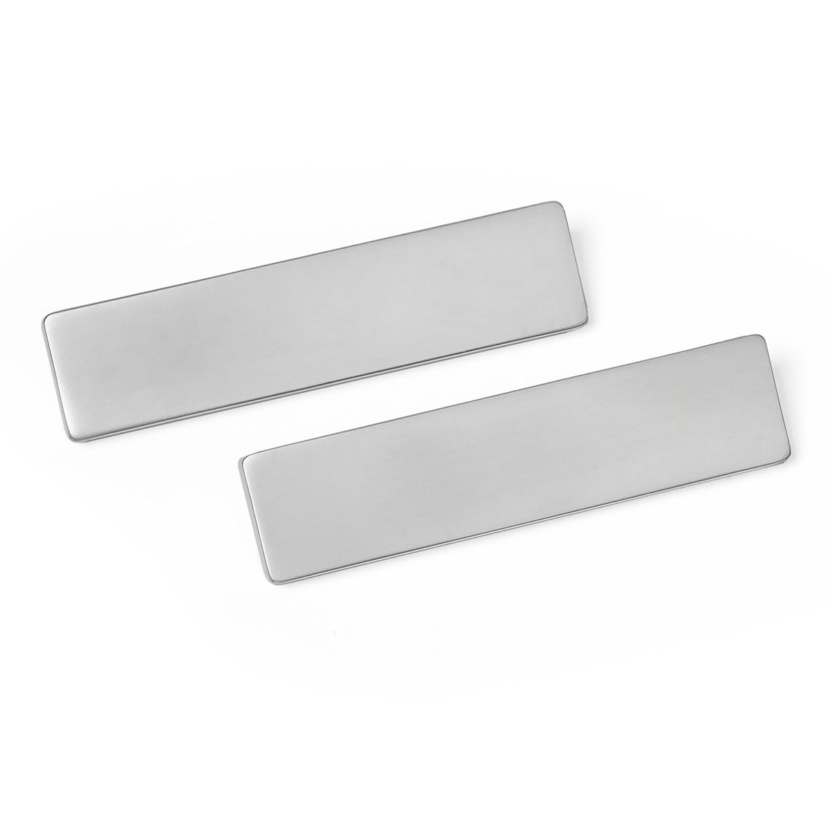 A pair of stainless steel name badges on a white background.