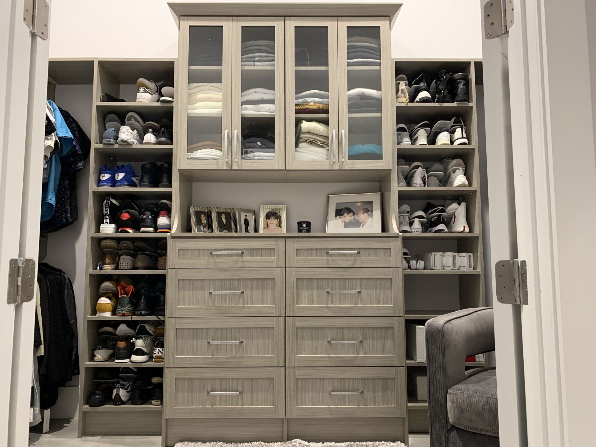 A walk in closet filled with lots of clothes and shoes.