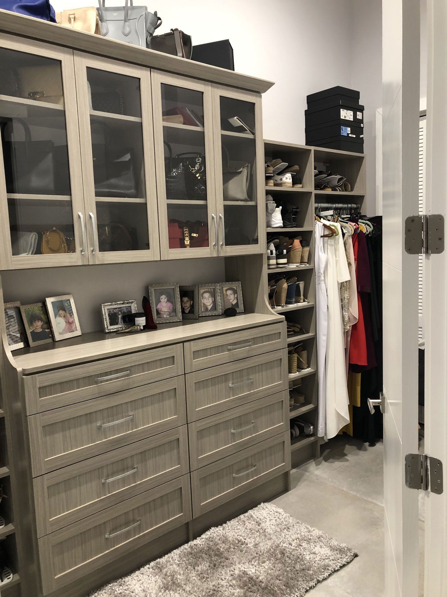 A walk in closet filled with lots of clothes and shoes.