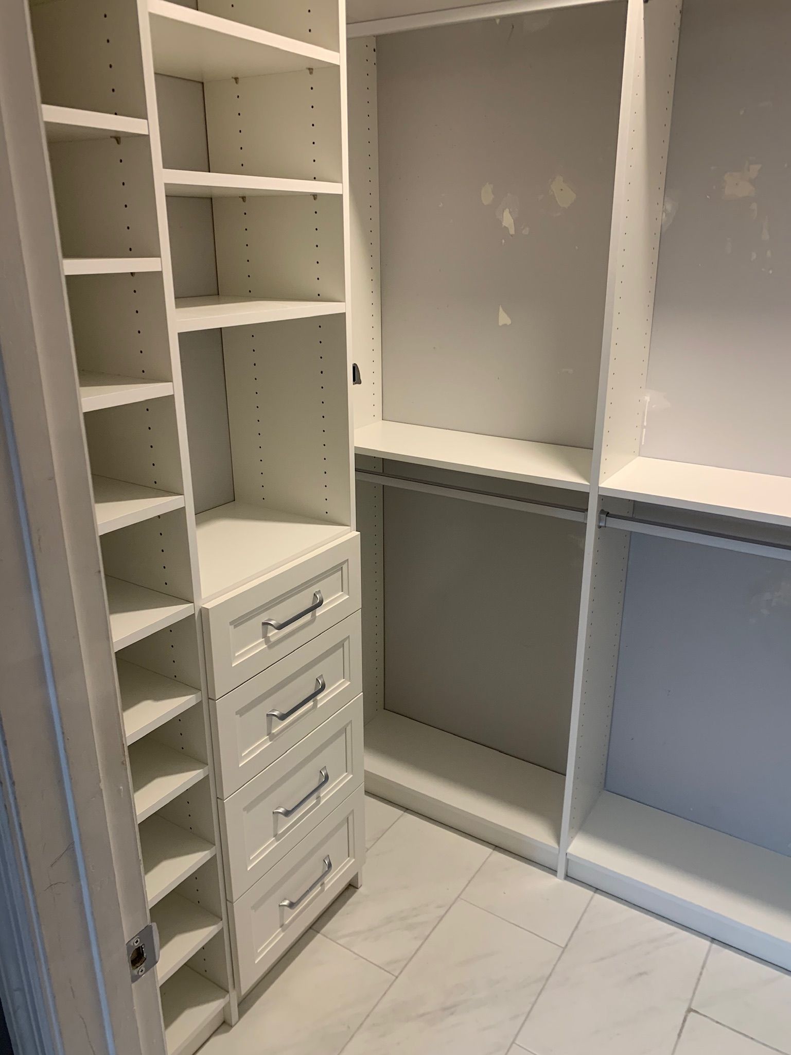 A walk in closet with lots of shelves and drawers
