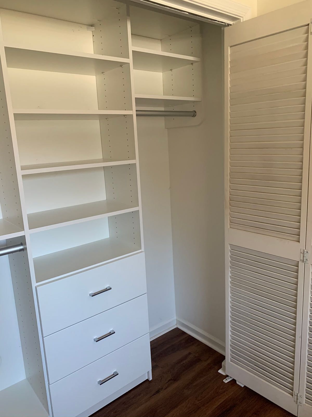 A walk in closet with lots of shelves and drawers.