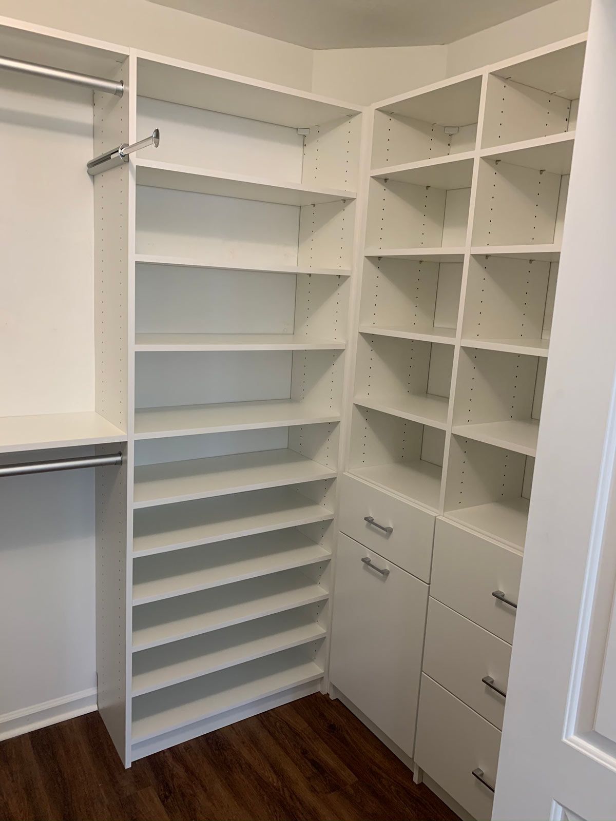 A walk in closet with lots of shelves and drawers.