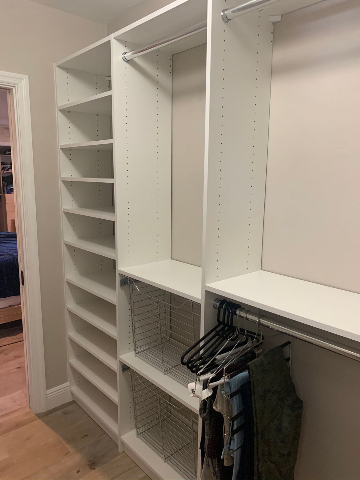 A walk in closet with lots of shelves and clothes hanging on racks.