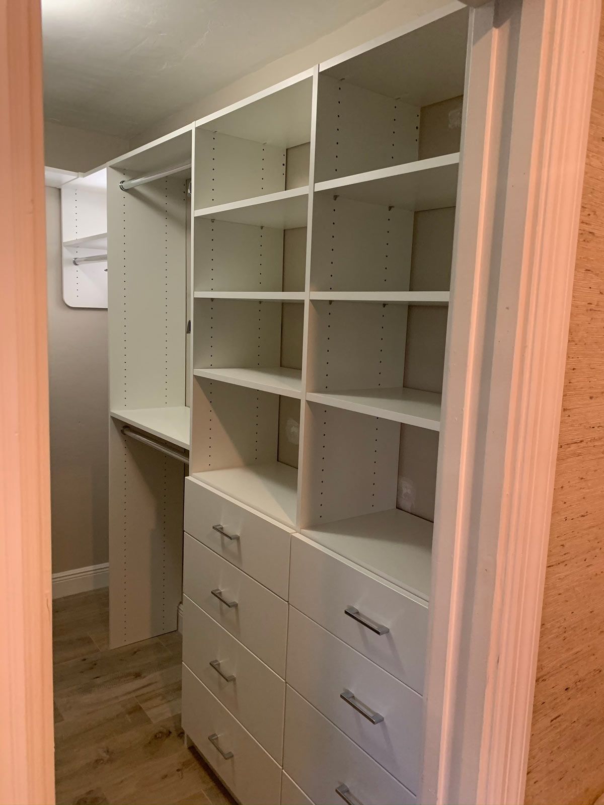 A walk in closet with lots of shelves and drawers.
