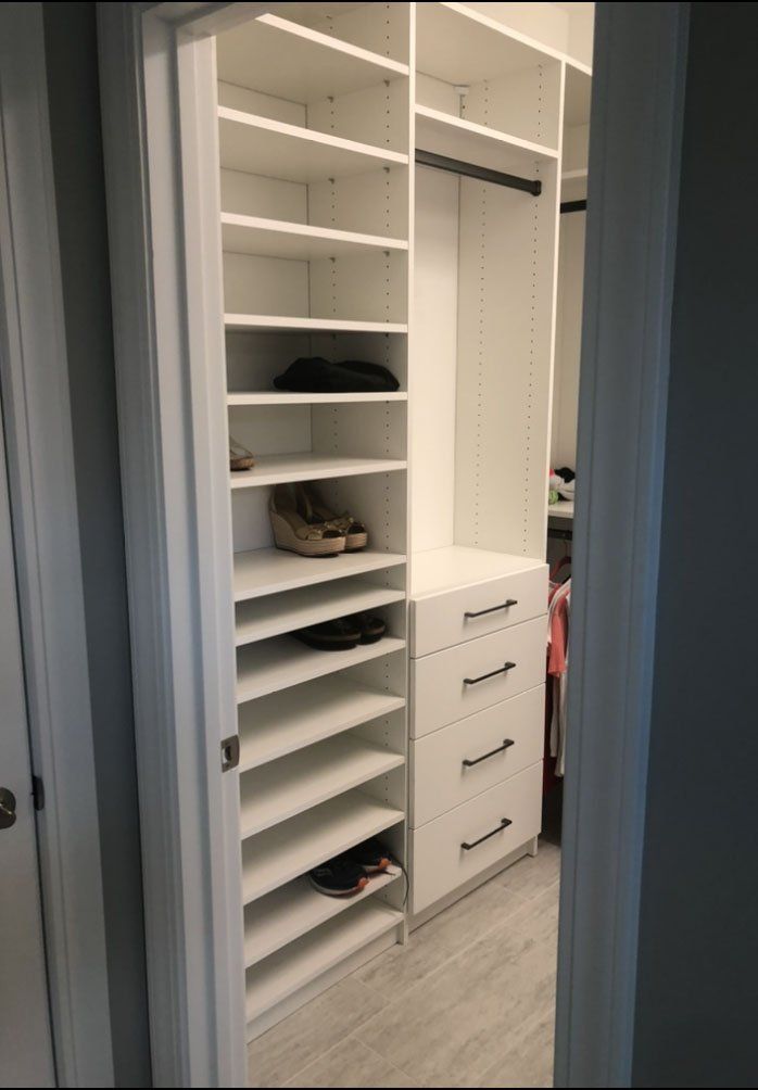 A walk in closet with lots of shelves and drawers